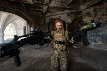 Caucasian woman in army uniform holding two machine guns. 