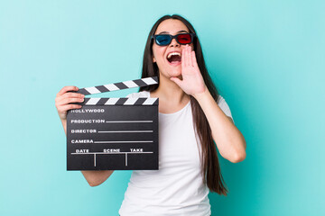 young adult woman feeling happy,giving a big shout out with hands next to mouth. movie concept