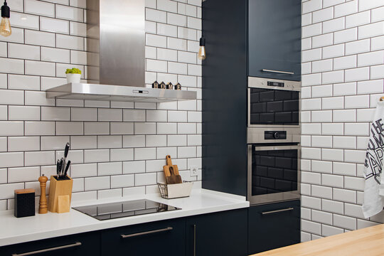 Stylish trendy kitchen with white tile and dark facades