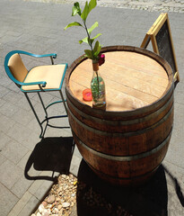 improvised table with a barrel of wine, with a plant and blue chair on one side - elegant vintage...