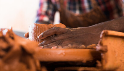 Close up of hands working on pottery wheel in workshop