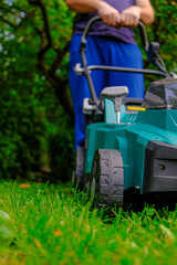 Lawn mowing. lawn mower close-up mows the lawn in the summer garden.Technique and equipment for the...