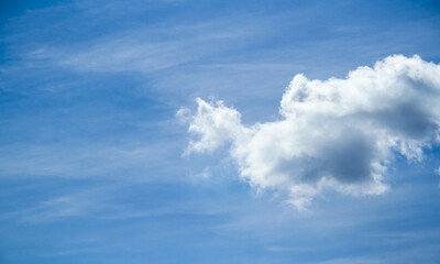 Summer sky. Cumulus clouds on a blue background. Partly cloudy.