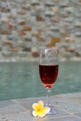 glass of wine on table with pool