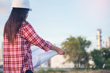 Woman construction engineer hold blueprint wear plaid shirt safety white hard hat at construction site industry labor worker. Architecture Female engineer civil worker look at blueprint real estate