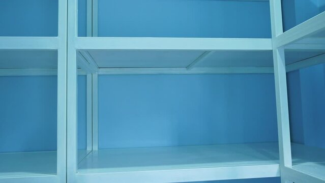 4K Video of empty white shelves in blue storage room