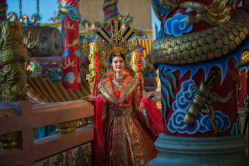 Portrait of a woman. portrait of a woman. person in traditional costume. woman in traditional costume. Beautiful young woman in a bright red dress and a crown of Chinese Queen posing. 