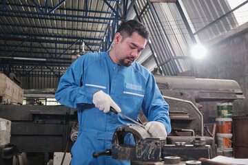 One professional Asian male industry engineer worker works in a safety uniform with metalwork precision tools, mechanical lathe machines, and spare parts workshop in the steel manufacturing factory.