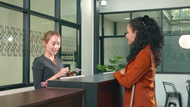 Female tourist in international airport at check-in counter checking staff giving passport and boarding pass from the attendant for he flight, travel and holiday season trip concept