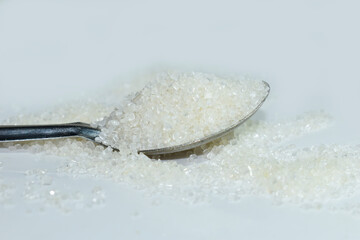 Sweet sugar in the spoon isolated on white background