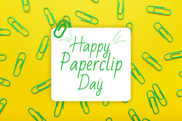 Many paperclips on yellow background. Greeting card for National Paperclip Day
