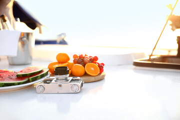 Photo camera with fresh fruits on deck of yacht
