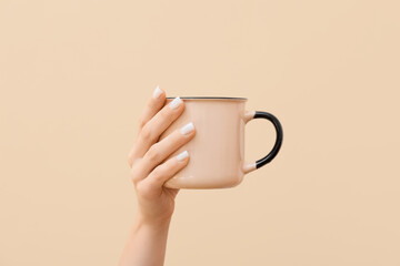 Woman holding ceramic cup on color background, closeup