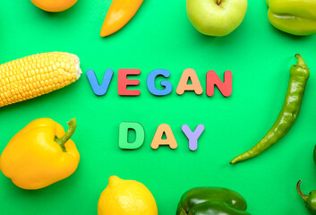 Text VEGAN DAY, different vegetables and fruits on green background, closeup