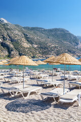 Fototapeta na wymiar Beach umbrellas and sun loungers on Oludeniz Beach in Turkey