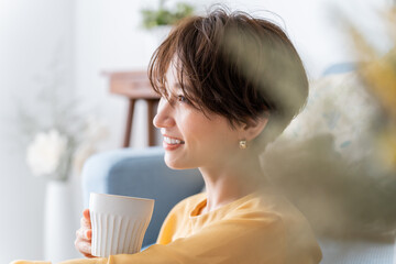 コップを持ちメイクをしたきれいな日本人女性の横顔アップ
