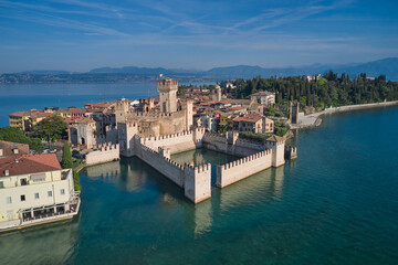 Fototapeta na wymiar Aerial view of Sirmione, an ancient village on southern Garda Lake. Popular travel destination on Lake Garda in Italy. Scaligero Castle drone view. Sirmione top view.