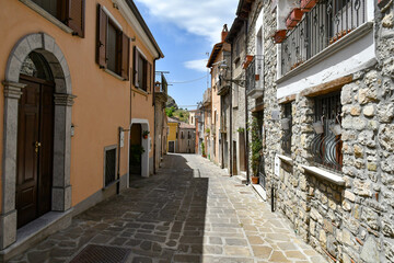 A narrow street between the old houses of Sasso di Castalda, a village in the mountains of Basilicata, Italy.