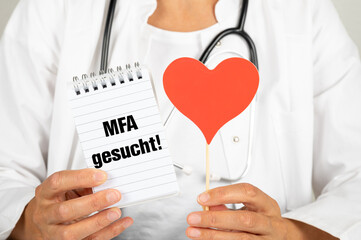 Hausärztin mit einem Notizblock auf dem MFA gesucht steht und einem roten Herz