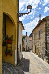 A narrow street between the old houses of Sasso di Castalda, a village in the mountains of Basilicata, Italy.