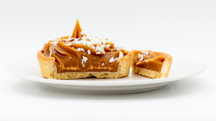 Closeup photo of a gourmet caramel tart with white chocolate flakes