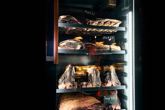 Fridge with delicatessen meats with date tags in restaurant