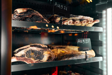 Aging delicatessen meats with date tags in refrigerator