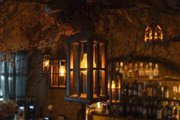 Old fashioned lantern with glowing lamp in empty pub
