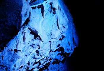 Formation rocheuse calcaire au cœur d'une grotte, éclairée par une lumière bleue