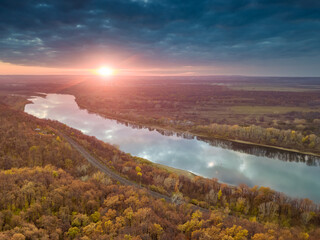 Aerial view of dramatic sunset sky reflecting in river, at autumn time