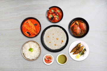 Assorted Indian seafood dishes. Bangda Fry, Crabs, Prawns and pomfret curry, Tandlachi Bhakri, Rice, and gulab jamun. along with green chutney and salad. Copy space. Malwani fish thali. Maharashtrian 
