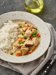 Chicken stew with vegetables and mushroom cream sauce. Tender chicken fillet in a creamy mushroom sauce with rice and green peas.