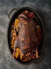 A Christmas recipe for roasted goose stuffed with baked apples, on a gray background