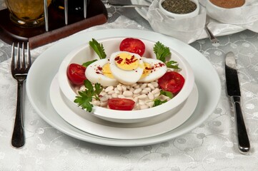 A plate of piyaz. Piyaz is a salad unique to Turkish cuisine. It is made with white beans, onions, tomatoes, spices, lemon and olive oil.
