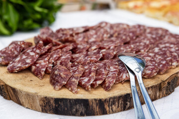 Typical wedding banquet. Wooden cutting board with salami.