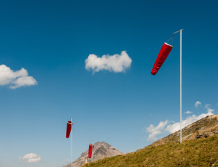 Wind socks in the alps in front of blue sky.