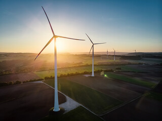 Group of Windmills in aerial drone view in golden sunset.