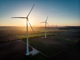 Group of Windmills in aerial drone view in golden sunset.