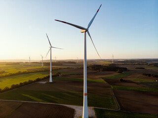 Group of Windmills in aerial drone view in sunset.