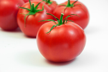 ripe tomatoes on a white background. the concept of cooking tomato sauce. red vegetables on a light texture. juicy pink tomatoes on the table