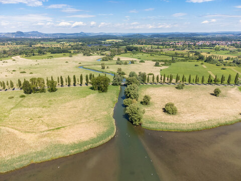 Die Radolfzeller Aach m&uuml;ndet in den westlichen Bodensee, am Horizont die Hegauberge