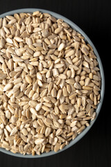 Raw Organic Sunflower Seed Kernels in a Blue Bowl, top view. Flat lay, overhead, from above. Close-up.