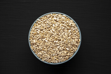 Raw Organic Sunflower Seed Kernels in a Blue Bowl, top view. Flat lay, overhead, from above.