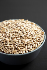 Raw Organic Sunflower Seed Kernels in a Blue Bowl, side view. Close-up.