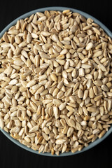 Raw Organic Sunflower Seed Kernels in a Blue Bowl, top view. Flat lay, overhead, from above.