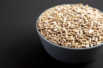 Raw Organic Sunflower Seed Kernels in a Blue Bowl, side view. Space for text.