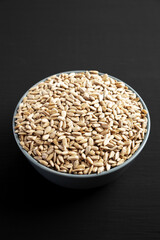 Raw Organic Sunflower Seed Kernels in a Blue Bowl, side view.