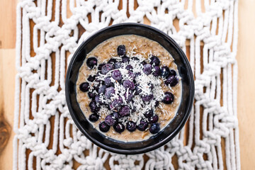 Obraz na płótnie Canvas healthy plant-based food, vegan oatmeal porridge with blueberries and coconut
