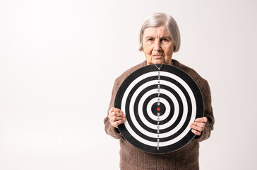 Octogenarian old lady holding target in her wrinkled hands.