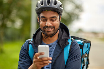 food shipping, technology and people concept - happy smiling delivery man in bicycle helmet with...